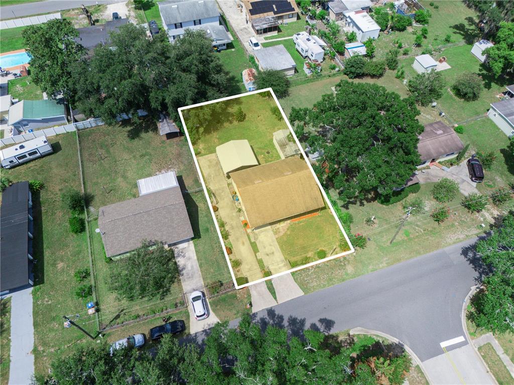 A single-story house with a brown shingled roof and a screened-in front porch — 1213 CHEROKEE DRIVE, KISSIMMEE, FL