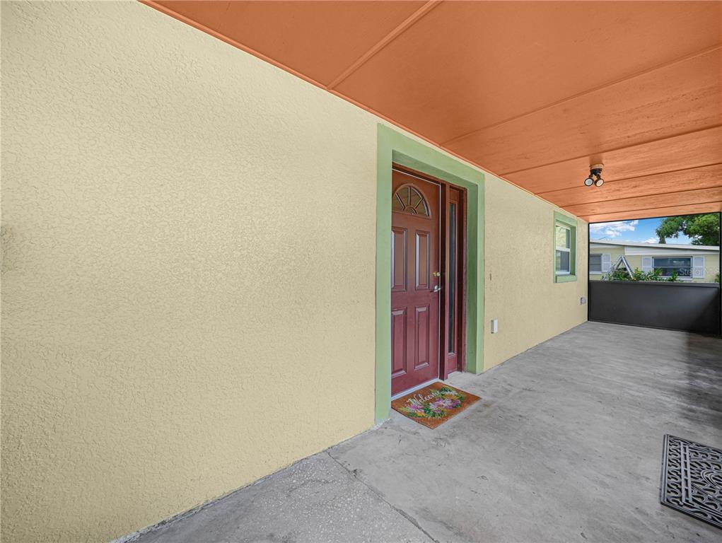 The exterior of a house features a screened-in porch, a shingled roof, and a walkway — 1213 CHEROKEE DRIVE, KISSIMMEE, FL