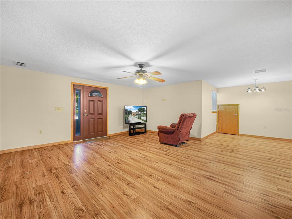 The exterior of a house features a stucco wall, wood-paneled gable, and a covered carport — 1213 CHEROKEE DRIVE, KISSIMMEE, FL
