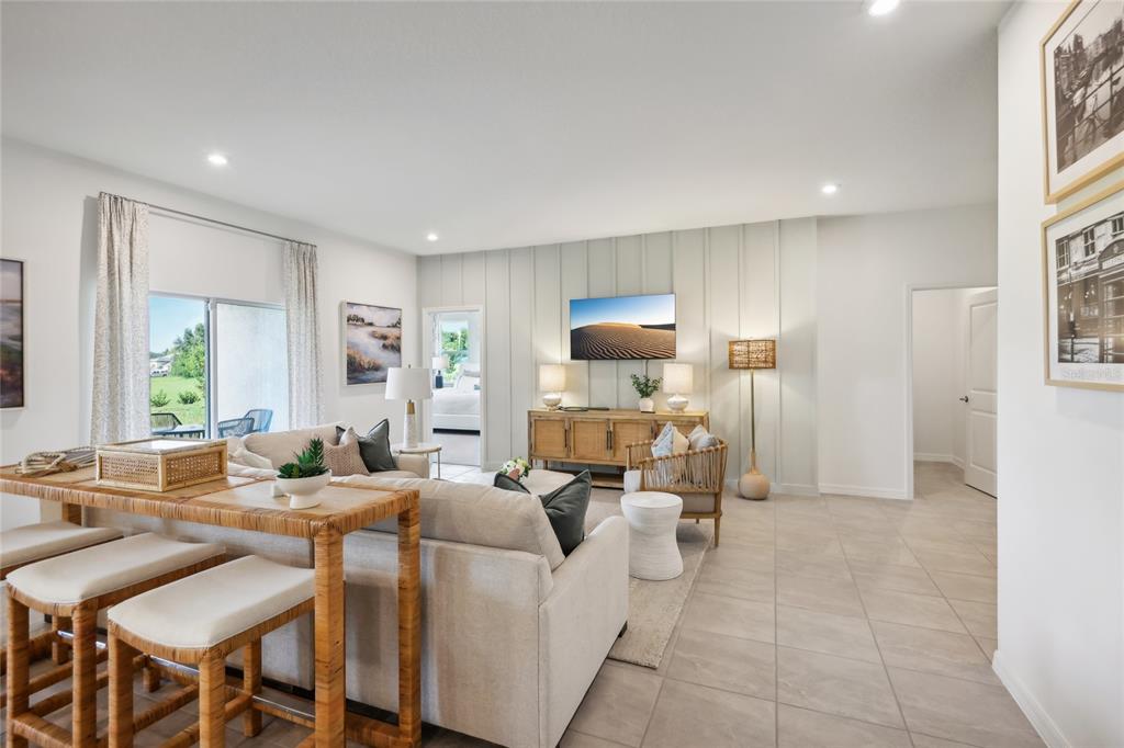 A living room features a sofa, a console table, and a wall with vertical paneling — 12918 CARA COURT, GRAND ISLAND, FL