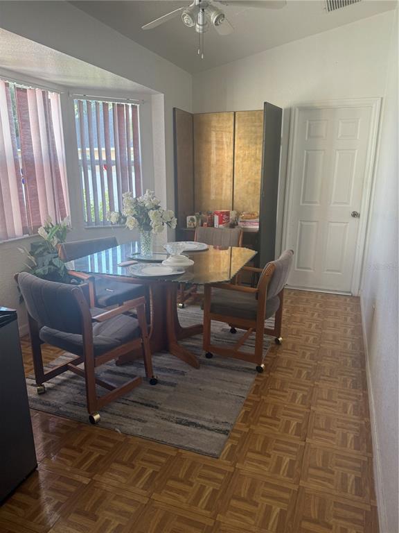 A dining area features a glass-top table, four chairs, parquet flooring, and a bay window — 7455 W PRICE BOULEVARD, NORTH PORT, FL
