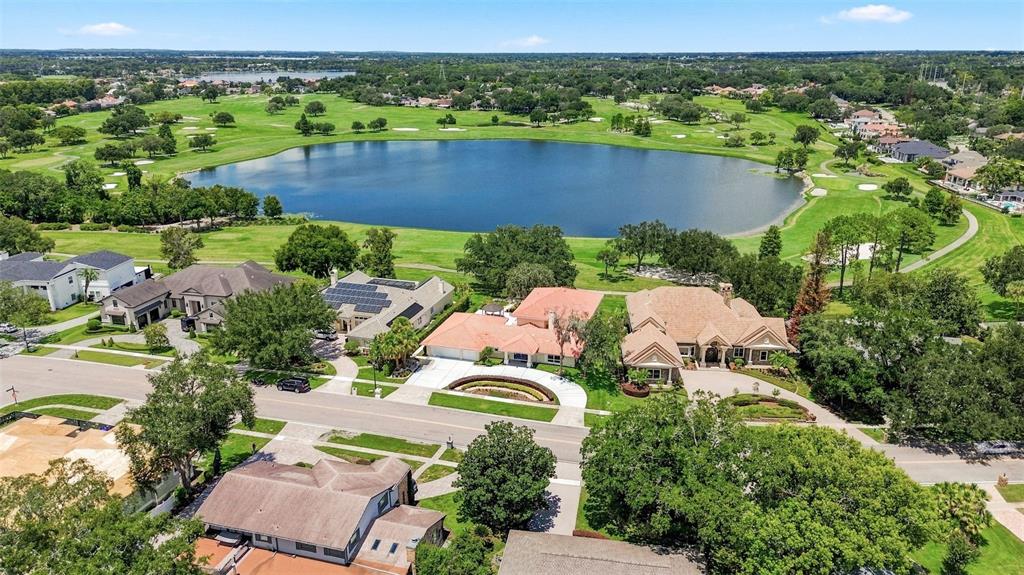 An aerial view shows several suburban houses situated along a golf course and a lake — 5912 TARAWOOD DRIVE, ORLANDO, FL