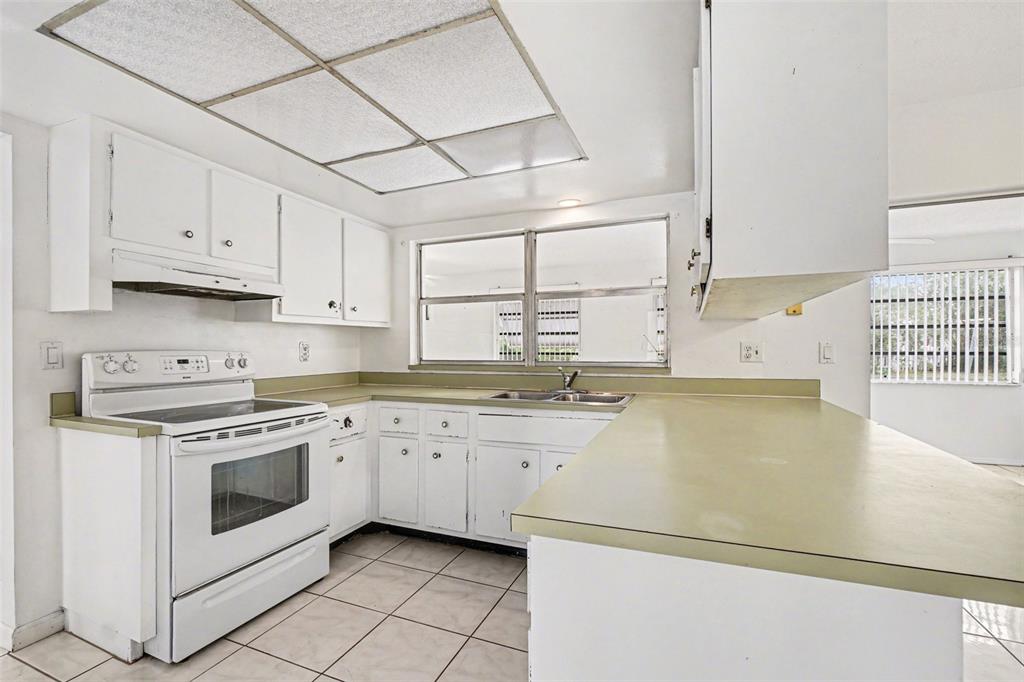 A single-story house with a beige stucco exterior, arched windows, and two palm trees — 6535 MARIUS ROAD, NORTH PORT, FL