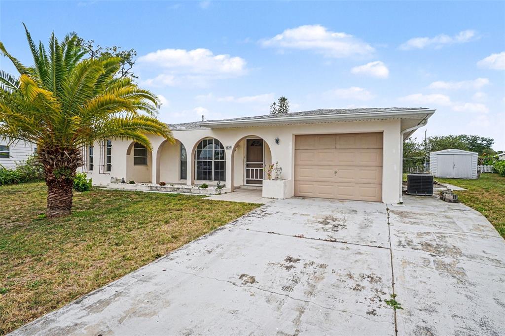 A bright room features light blue walls, white tiled floors, a front door, and large windows — 6535 MARIUS ROAD, NORTH PORT, FL
