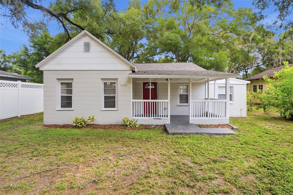 A single-story house with a white exterior, a red front door, and a covered porch — 4209 N DOWNING AVENUE, TAMPA, FL