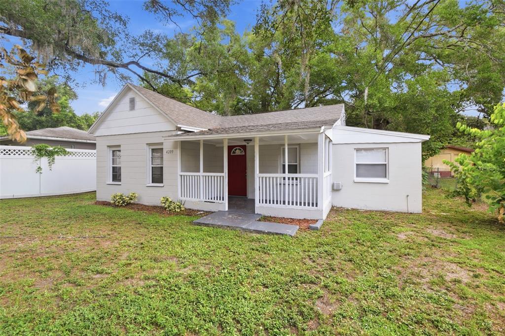 A single-story house with a white exterior, a red front door, and a covered porch — 4209 N DOWNING AVENUE, TAMPA, FL