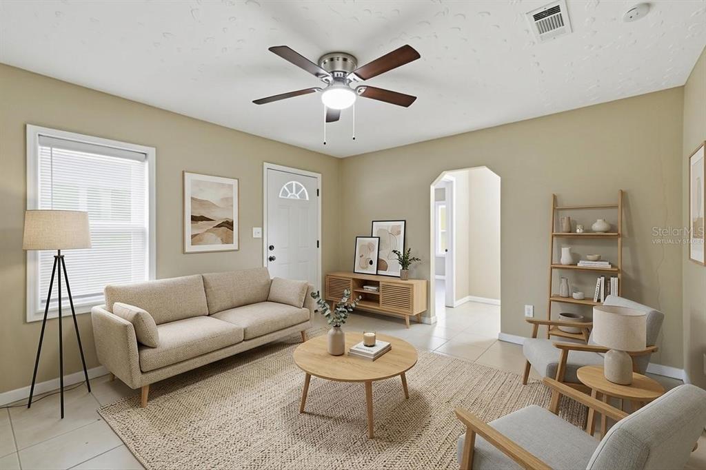 This virtually staged living room features a beige sofa, two armchairs, and a ceiling fan — 4209 N DOWNING AVENUE, TAMPA, FL