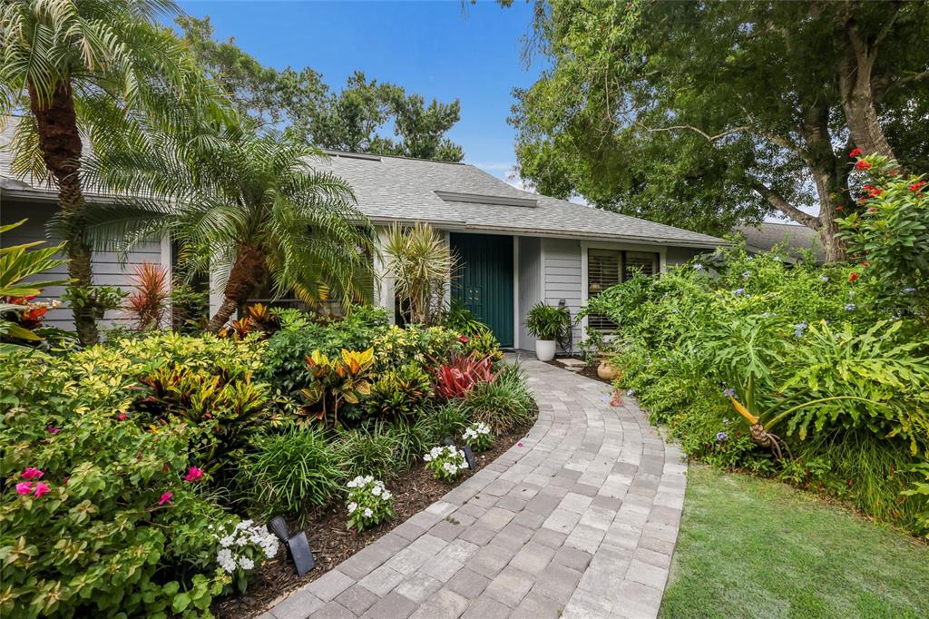 An entryway with tile flooring leads into a living room with a fireplace and windows — 851 FAULKWOOD COURT, SARASOTA, FL