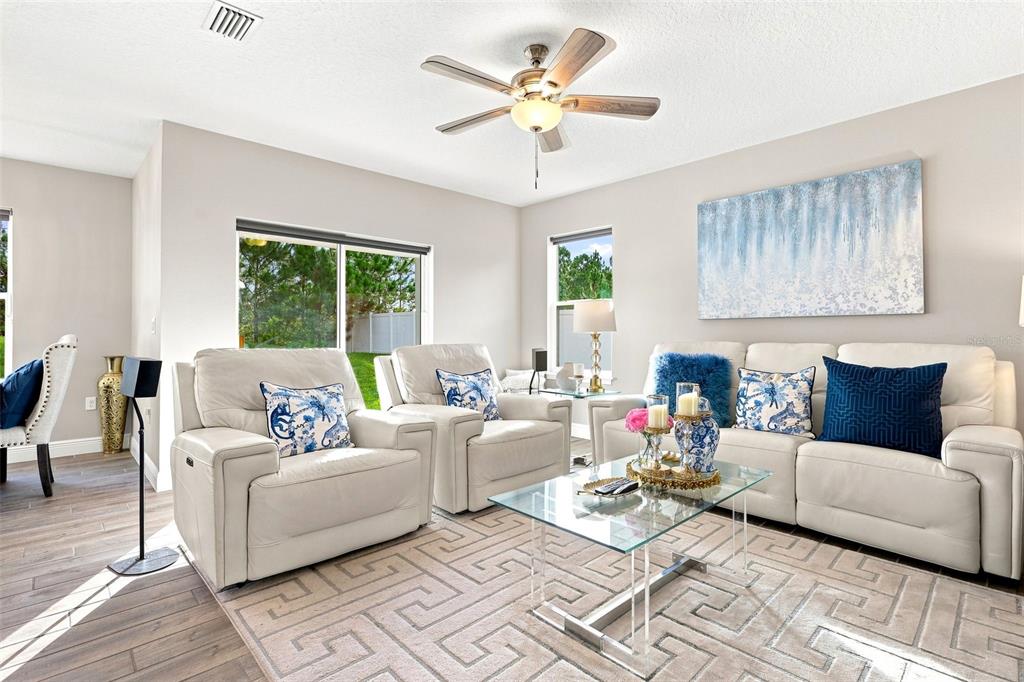 A modern kitchen features white cabinets, granite countertops, a central island, and three bar stools — 520 S SHELL ROAD, DELAND, FL