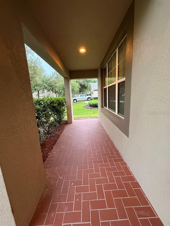 A covered entryway features red brick pavers in a herringbone pattern and a recessed light — 5823 BUTTERFIELD STREET, RIVERVIEW, FL