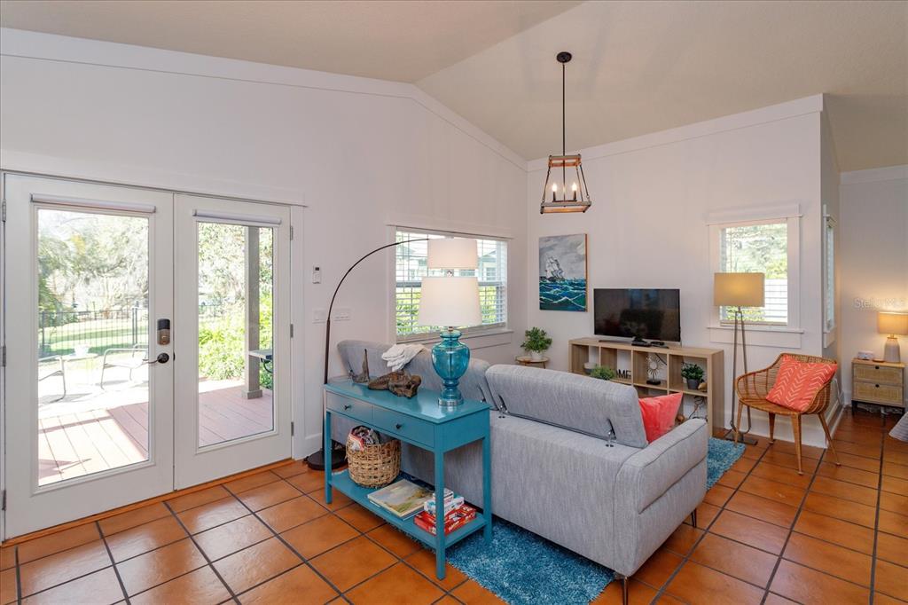 A living room features a gray sofa, a blue console table, and terracotta tile flooring — 1802 CHAMBERLIN STREET, ORLANDO, FL