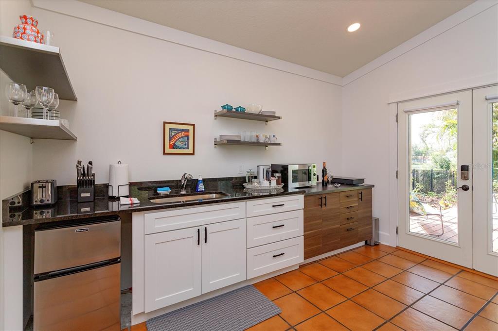 A kitchen area features white and wood cabinets, a dark countertop, and a glass door — 1802 CHAMBERLIN STREET, ORLANDO, FL