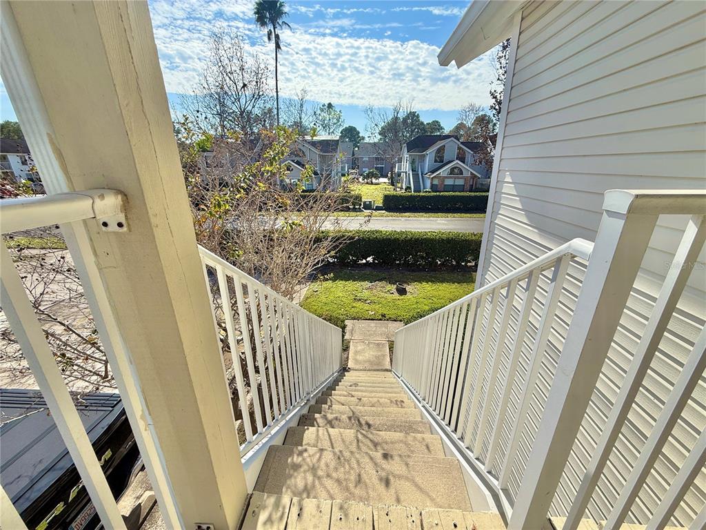 An elevated view looking down a set of concrete stairs with white railings — 3115 FOX SQUIRREL DRIVE UNIT 3115, KISSIMMEE, FL