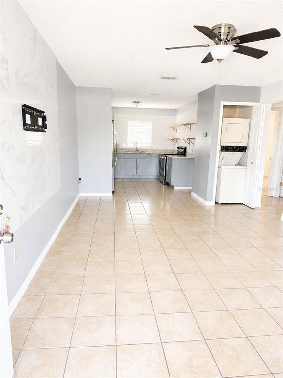 An open-concept kitchen and living area features light tile flooring and a ceiling fan — 1290 9TH STREET UNIT 108, DAYTONA BEACH, FL