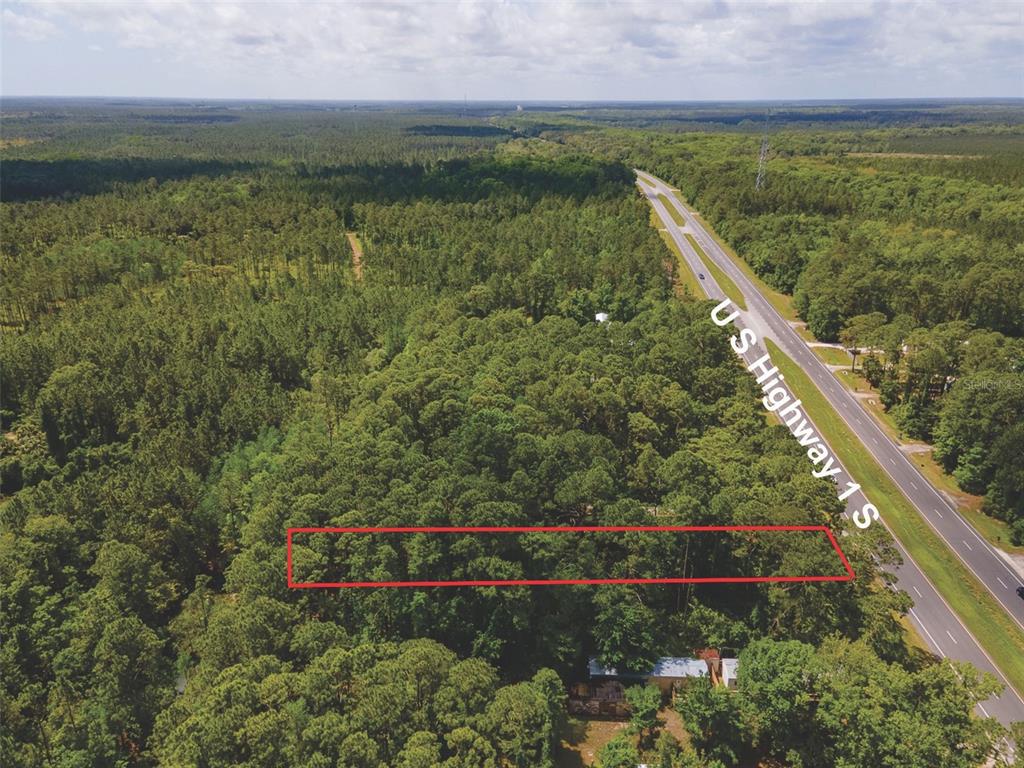An aerial view shows a rectangular plot of wooded land outlined in red near a highway — 9152 U S HIGHWAY 1, ST AUGUSTINE, FL