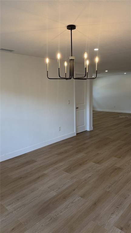A bedroom with light-colored walls, wood-look flooring, a ceiling fan, and an open closet — 1421 HEATHER DRIVE, DUNEDIN, FL