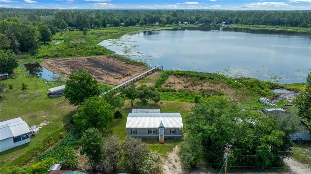 A single-story manufactured home sits on a grassy lot with a dirt driveway — 8581 NE 147TH COURT, SILVER SPRINGS, FL