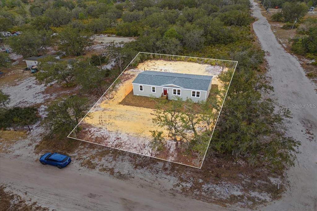 A single-story manufactured home with light green siding and red shutters sits on a lawn — 4510 CROWS BLUFF AVENUE, LAKE WALES, FL