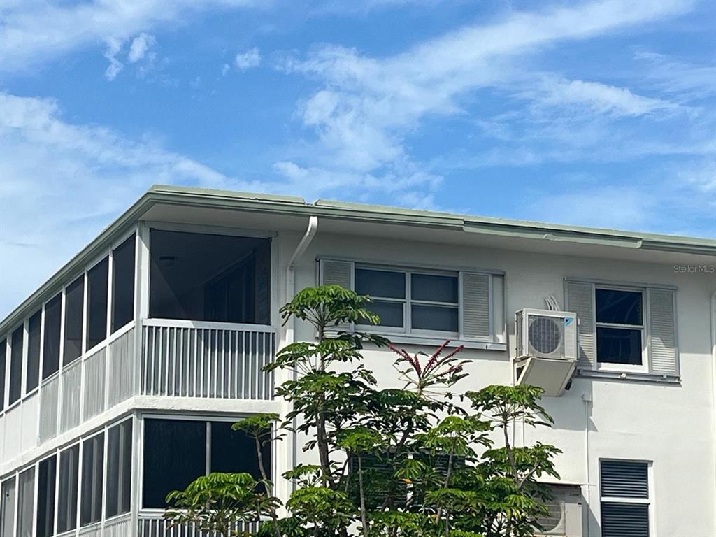 The exterior of a multi-story building features a screened balcony and a window-mounted air conditioner — 3600 N OCEAN DRIVE UNIT 310, RIVIERA BEACH, FL