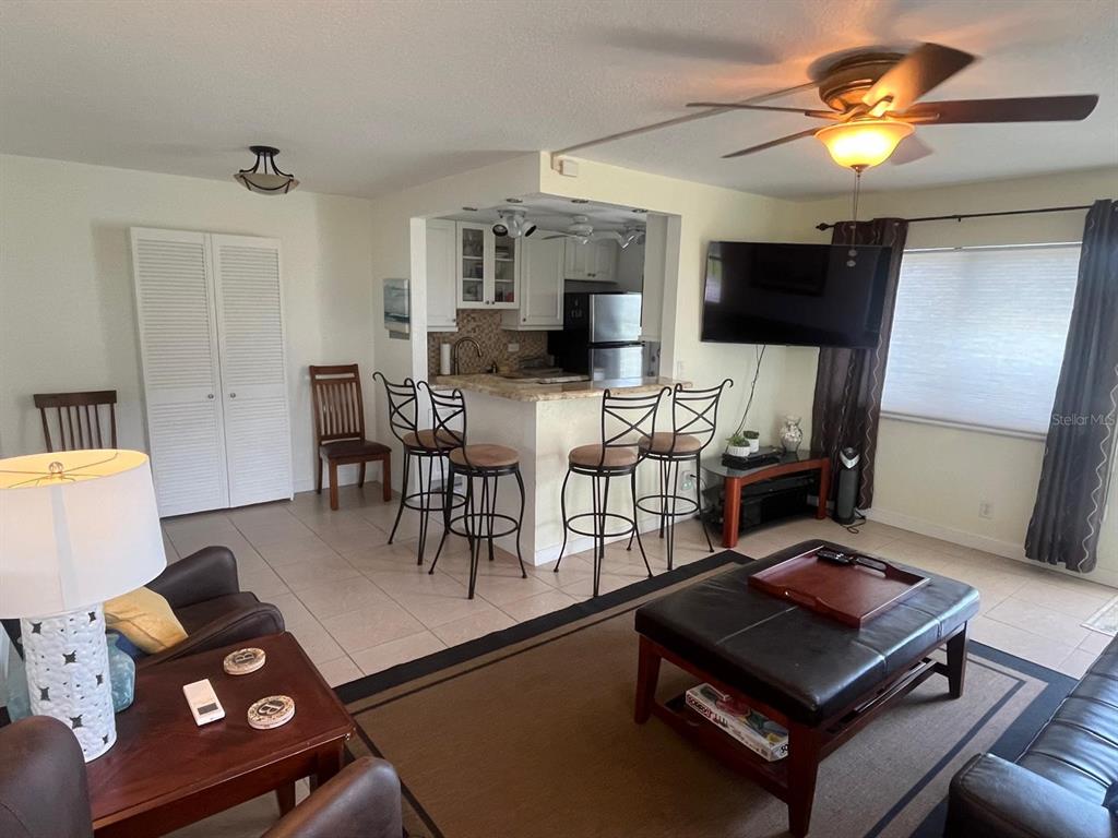 An open-concept living room and kitchen area featuring tile flooring and a breakfast bar — 3600 N OCEAN DRIVE UNIT 310, RIVIERA BEACH, FL