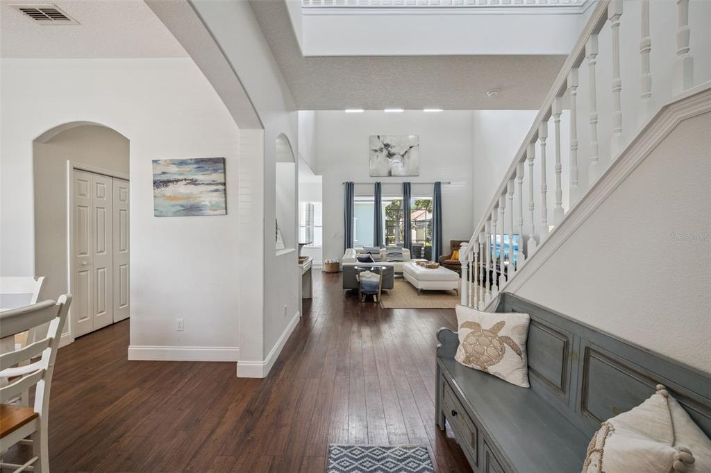 A view from an entryway looking into a living room with hardwood floors and stairs — 7412 DEVEREAUX STREET, REUNION, FL