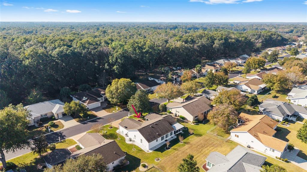 An aerial view shows a white suburban house with a dark roof and surrounding trees — 11283 SW 139TH PLACE, DUNNELLON, FL