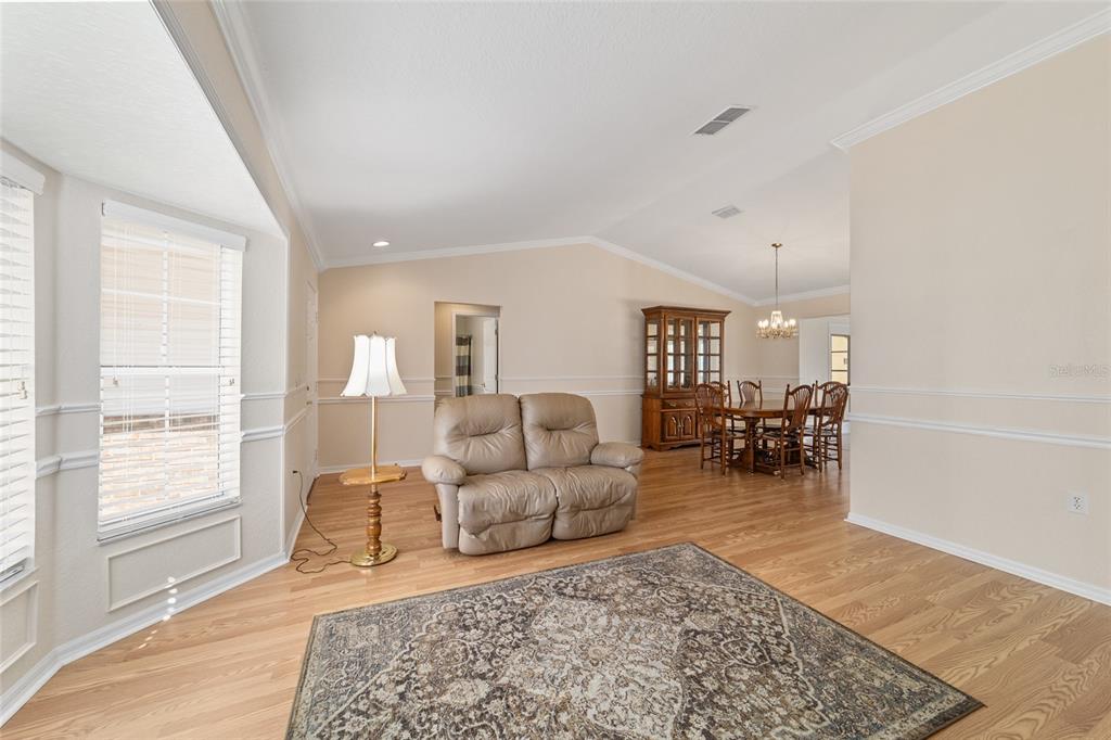 A living room and dining area with hardwood floors, a loveseat, and a china cabinet — 11283 SW 139TH PLACE, DUNNELLON, FL