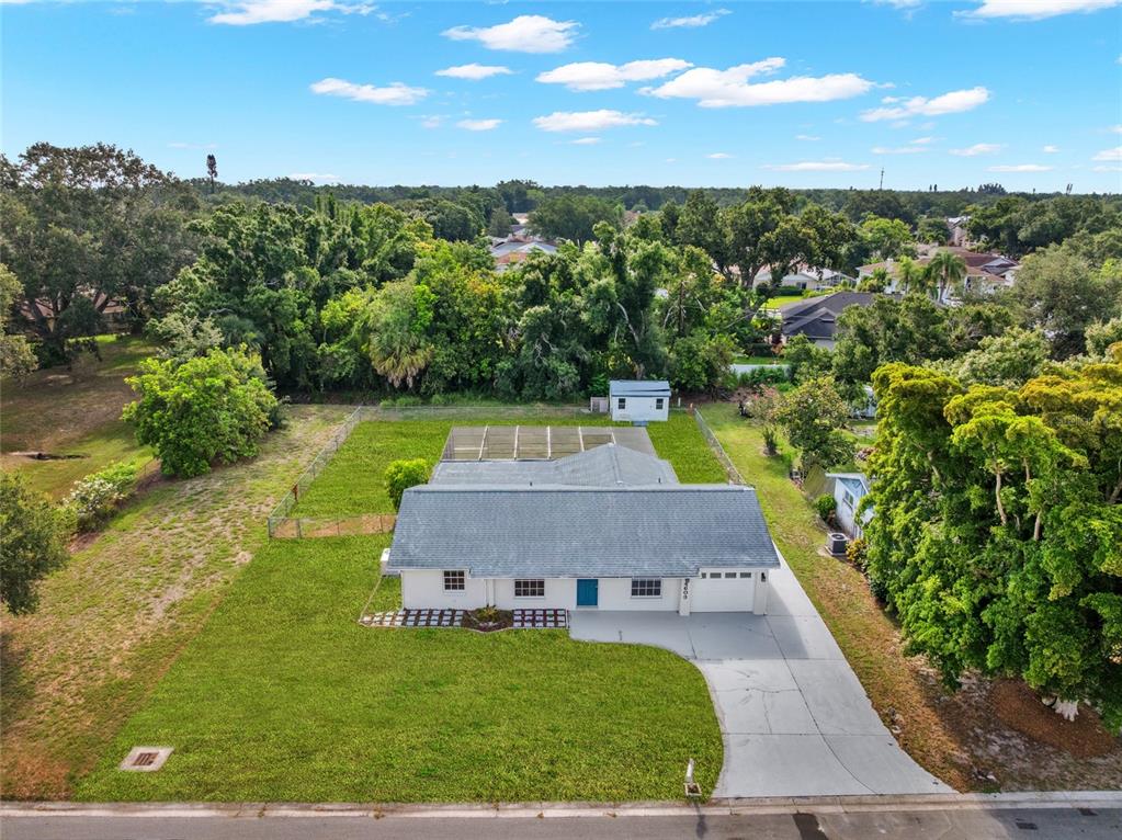 An aerial view shows a single-story house with a fenced backyard, pool cage, and driveway — 4603 ATLANTIC AVENUE, SARASOTA, FL