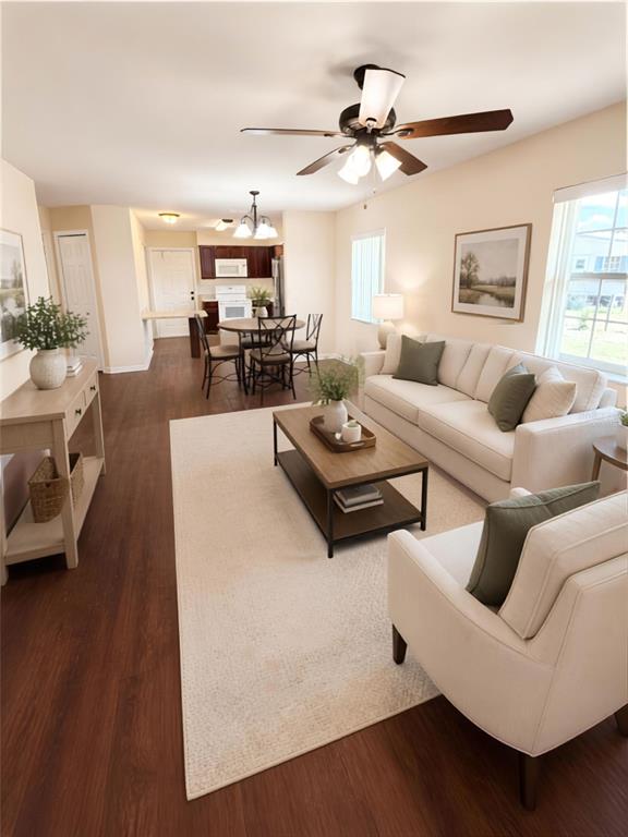 An open-concept living and dining area features wood-look flooring, a ceiling fan, and neutral furniture — 214 KING ROAD, WINTER HAVEN, FL