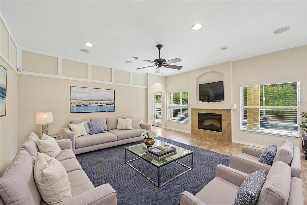 A living room features a fireplace, a ceiling fan, and neutral furniture on a rug — 8124 115TH AVENUE E, PARRISH, FL