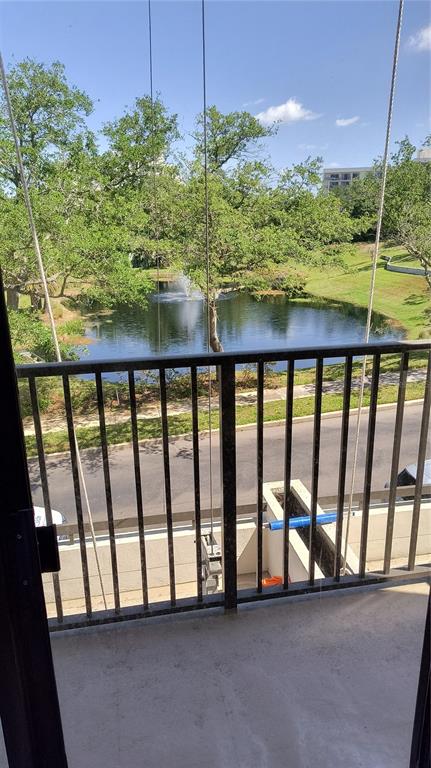 A view from a balcony overlooking a pond with a fountain and surrounding trees — 8 BELLEVIEW BOULEVARD UNIT 202, BELLEAIR, FL