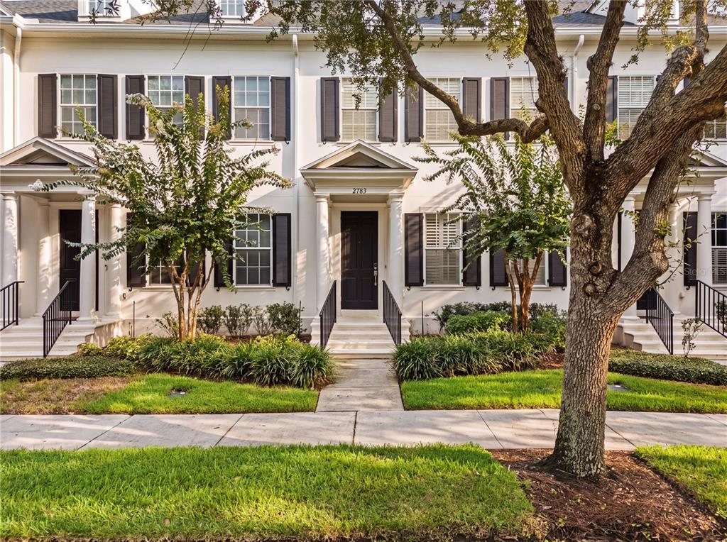 A row of white townhouses with black shutters, front porches, and landscaped yards — 2783 UPPER PARK ROAD, ORLANDO, FL