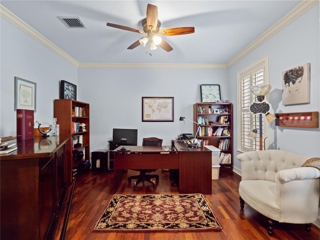 A home office features wood flooring, a desk, two bookshelves, and a tufted armchair — 2783 UPPER PARK ROAD, ORLANDO, FL