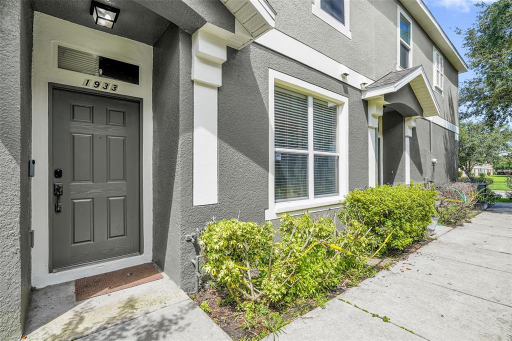 A two-story building with three garage doors, two upper-level balconies, and two parked cars — 1933 ESTANCIA CIRCLE UNIT 1933, KISSIMMEE, FL