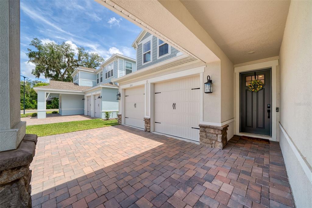 A paved driveway leads to a two-car garage and a front entrance with a dark door — 231 SEVERN WAY, ORLANDO, FL