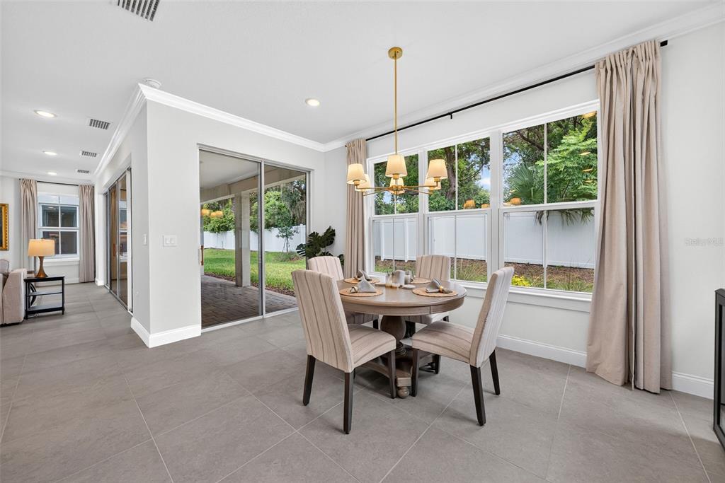 A dining area features a round wooden table, four upholstered chairs, and large glass doors — 231 SEVERN WAY, ORLANDO, FL