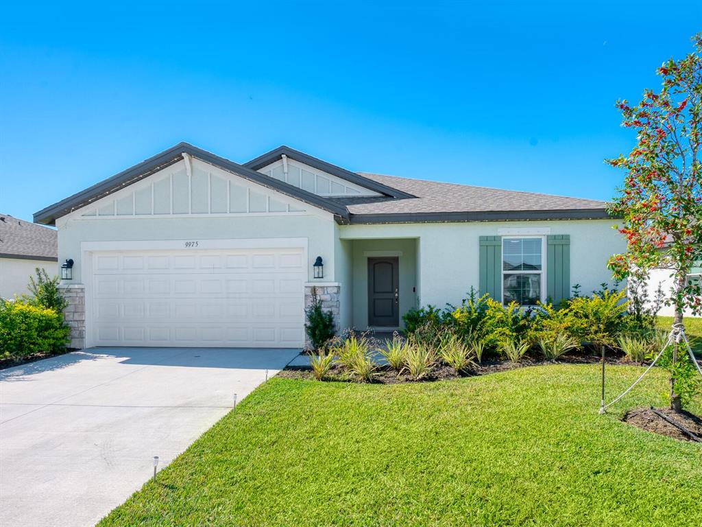 A single-story house with a white garage, light-colored stucco exterior, and green window shutters — 9975 LAST LIGHT GLEN, PARRISH, FL