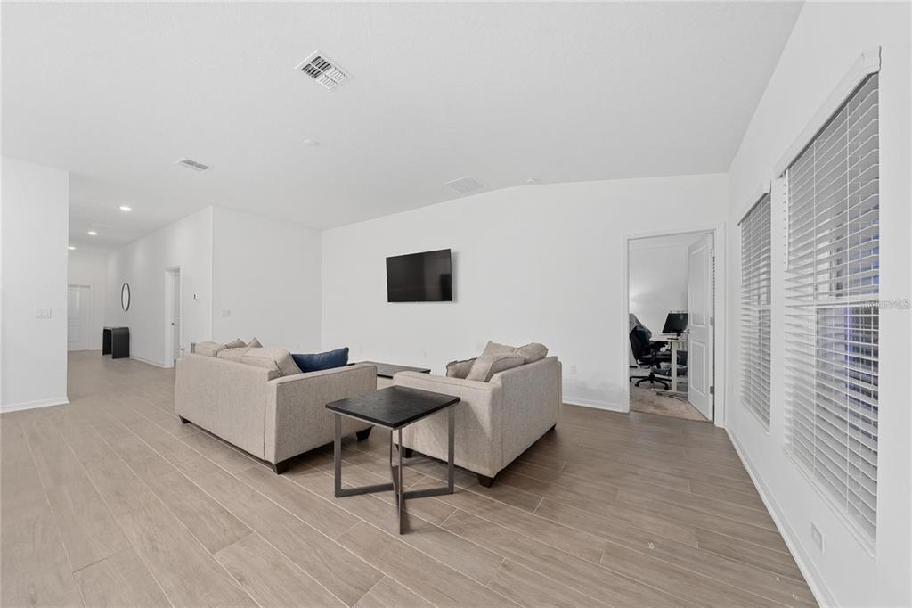 A modern kitchen features white cabinets, light countertops, stainless steel appliances, and a central island — 3977 WILLOWBROOK DRIVE, EDGEWATER, FL