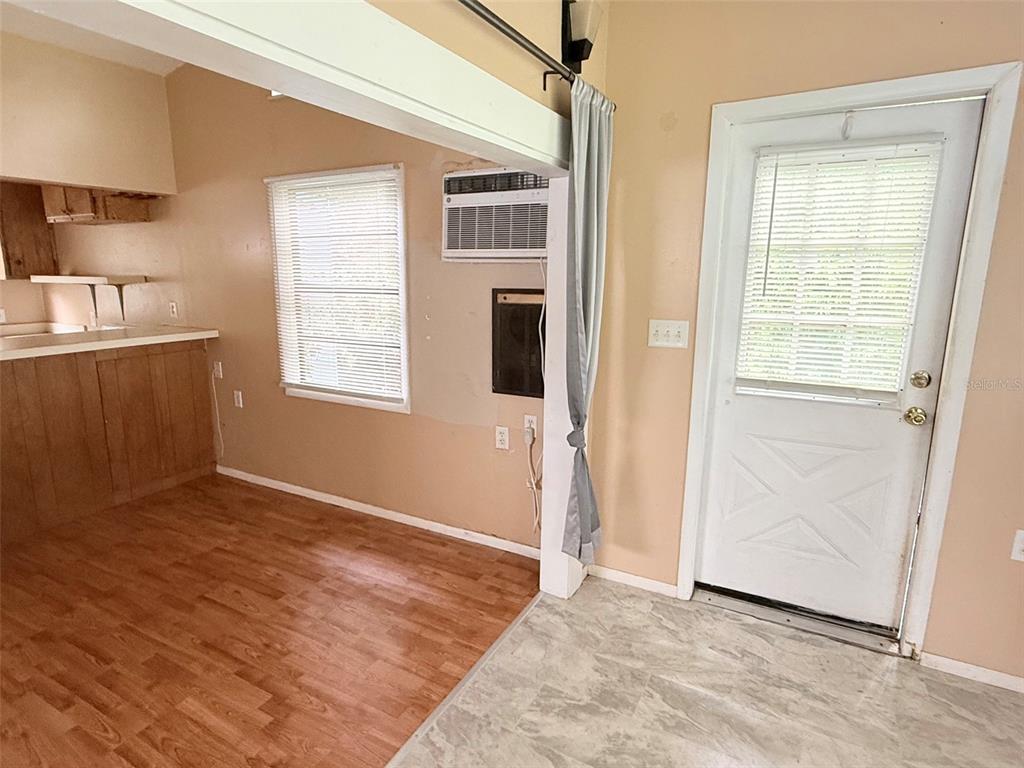 A room with gray walls, a brown carpeted area, and a wood-look laminate floor section — 1661 27TH AVENUE N, ST PETERSBURG, FL