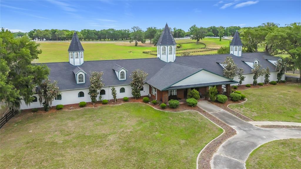 An aerial view of a large, single-story house with multiple turrets and a sprawling lawn — 6530 SE 156TH LOOP UNIT 3 & 4, SUMMERFIELD, FL