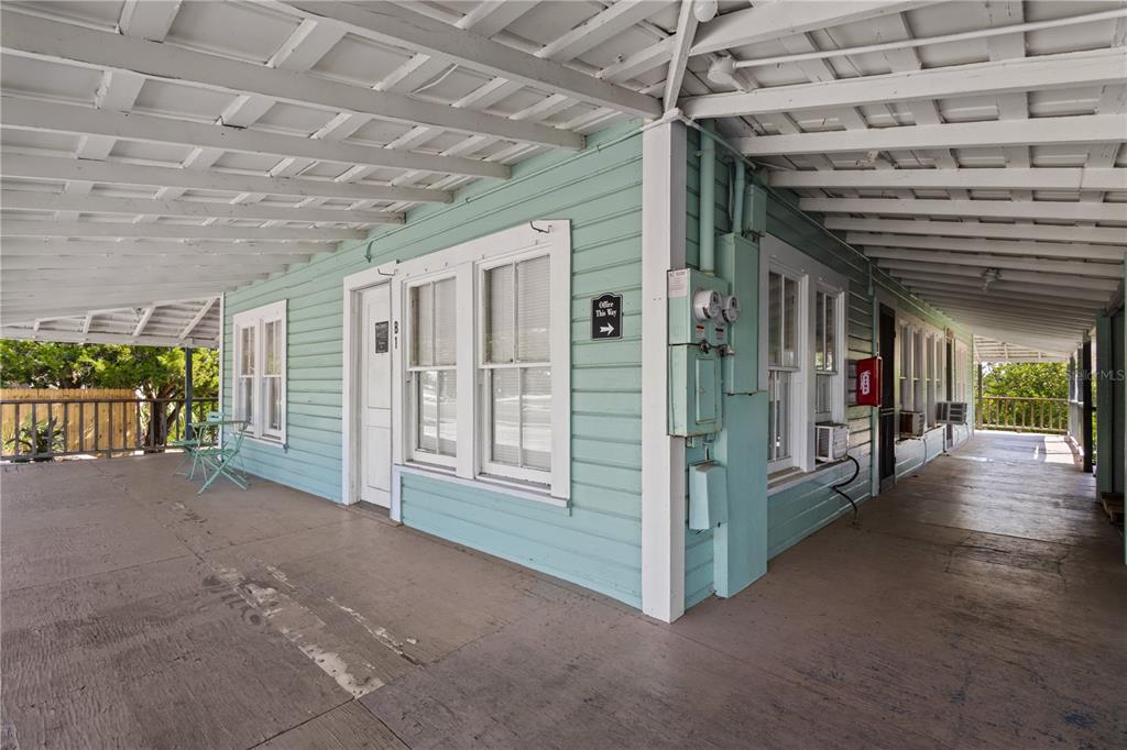 A covered porch with light blue siding wraps around the exterior of a building — 4051 D STREET, CEDAR KEY, FL