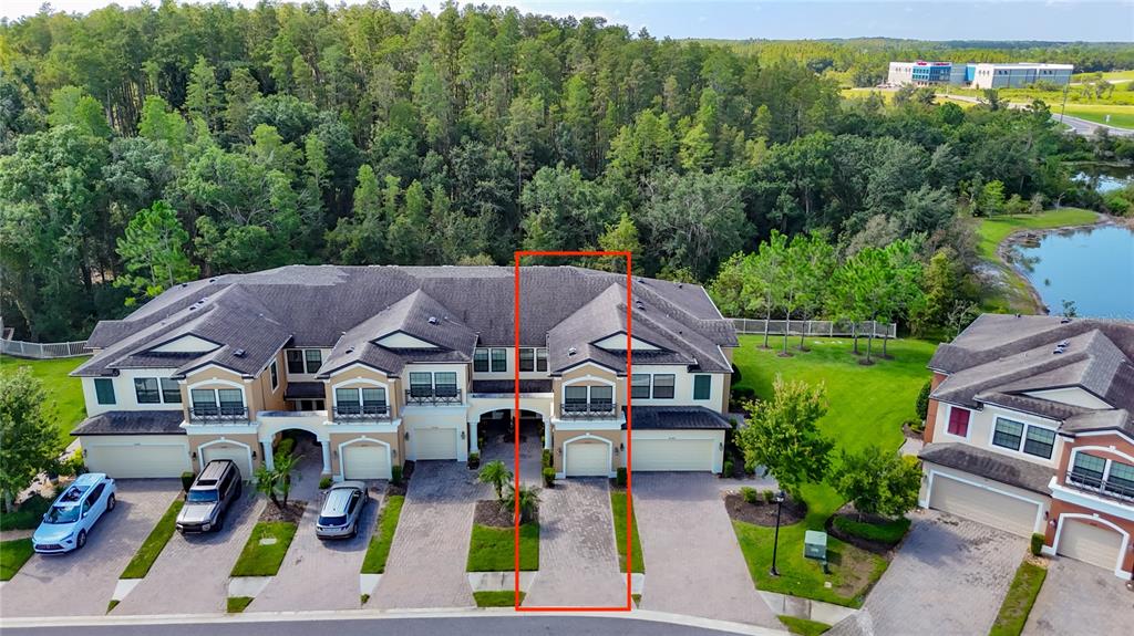 An aerial view shows a multi-unit townhouse building with a highlighted driveway and garage — 30305 SOUTHWELL LANE, WESLEY CHAPEL, FL