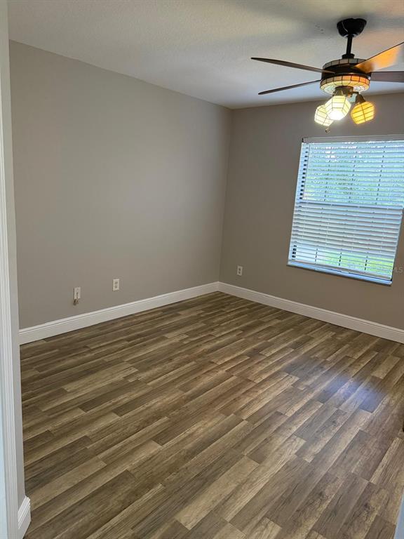 A living room with beige carpet, a ceiling fan, and a front door with windows — 6037 SCOTCHWOOD GLEN UNIT 8, ORLANDO, FL