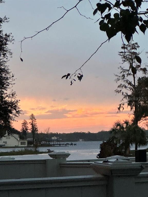 A view of a lake at sunset from a balcony with a white railing — 13709 JUNIPER BLOSSOM DRIVE UNIT 0, TAMPA, FL