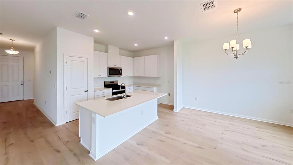 An empty bedroom features white walls, gray carpet, and a single window — 6205 SANDERS GROVE CIRCLE, OKAHUMPKA, FL