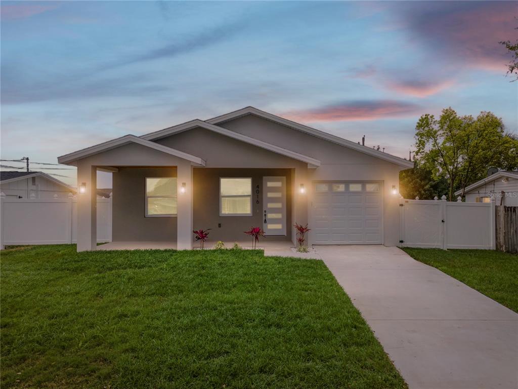 A single-story house with a gray exterior, a front porch, and a concrete driveway — 4016 BADEN DRIVE, HOLIDAY, FL