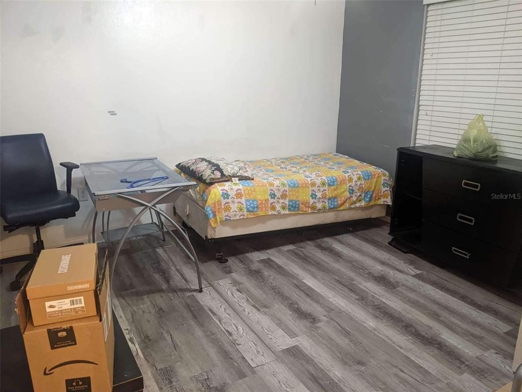 A bedroom features a single bed with a floral quilt, a desk, and a black dresser — 4000 SW 23RD STREET UNIT 4-103, #4, GAINESVILLE, FL