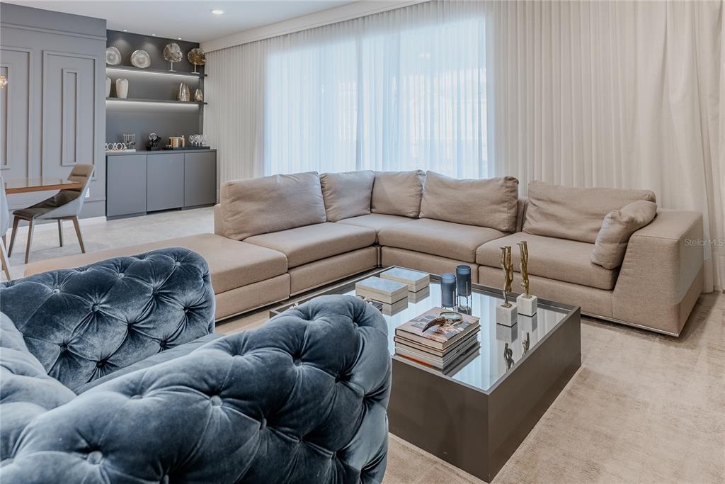 A living room features a large beige sectional sofa, a blue tufted armchair, and a coffee table — 2126 LELANI CIRCLE, DAVENPORT, FL