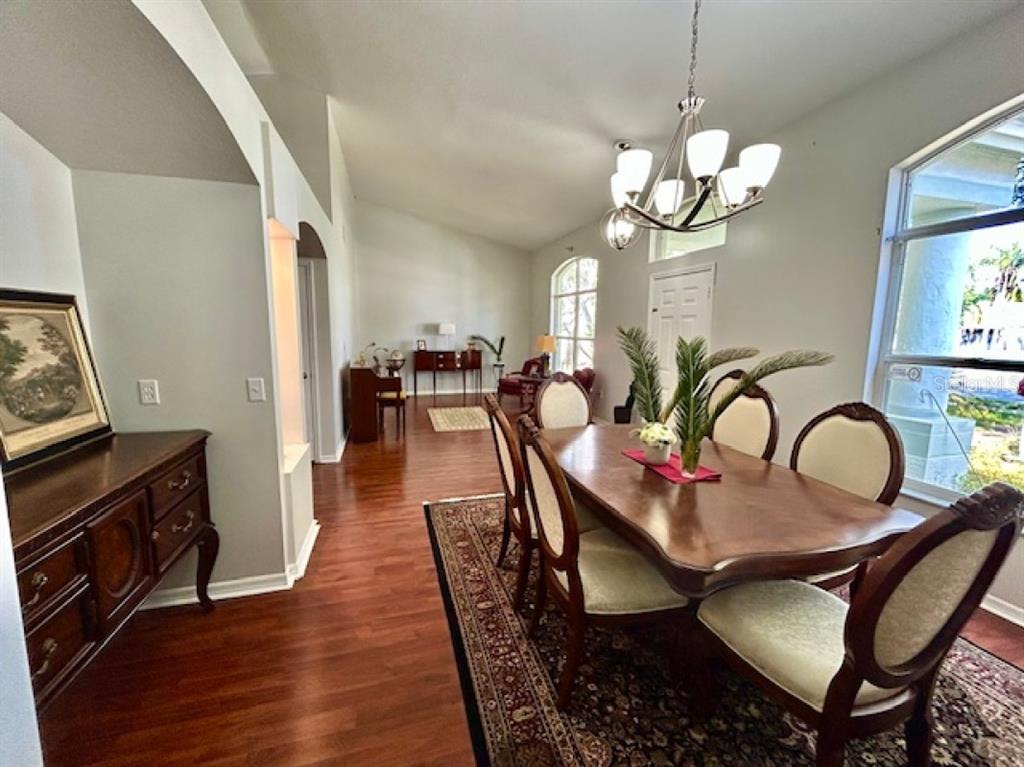 A dining room with a wooden table, six chairs, a chandelier, and hardwood floors — 1135 BIG SKY DRIVE, WESLEY CHAPEL, FL