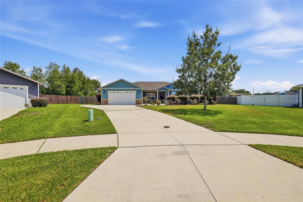 A blue single-story house with a two-car garage and a concrete driveway — 22971 NW 6TH LANE, NEWBERRY, FL